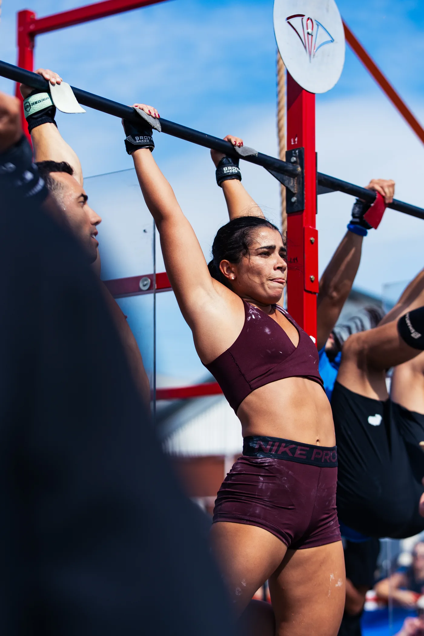 Atleta colgada de la barra con calleras Brothers Cargo durante Rosario Fitness Games