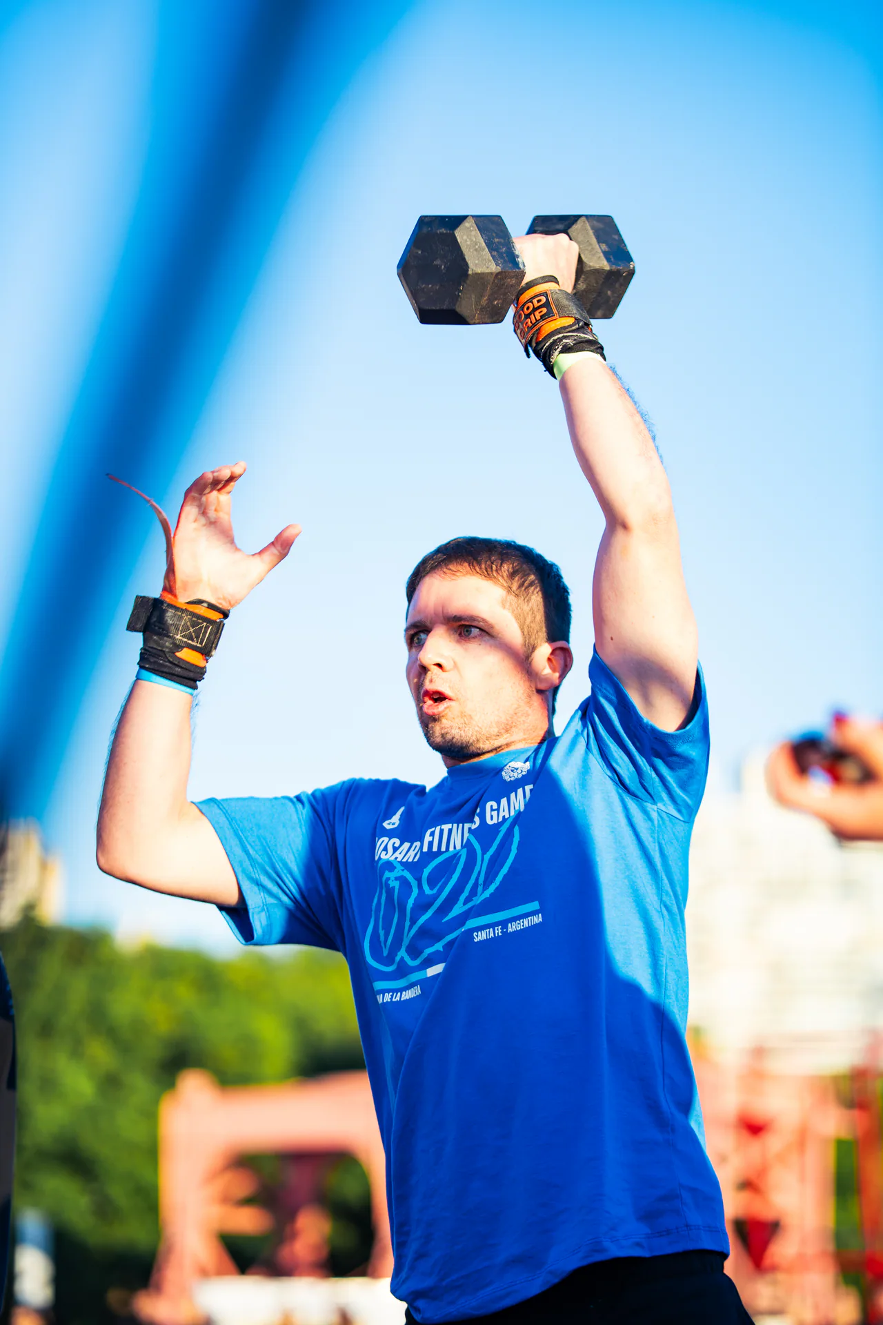 Atleta completando una repetición de mancuerna sobre la cabeza