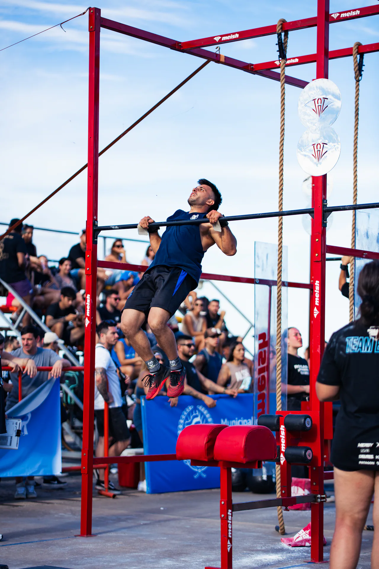 Atleta realizando una dominada en la estructura roja