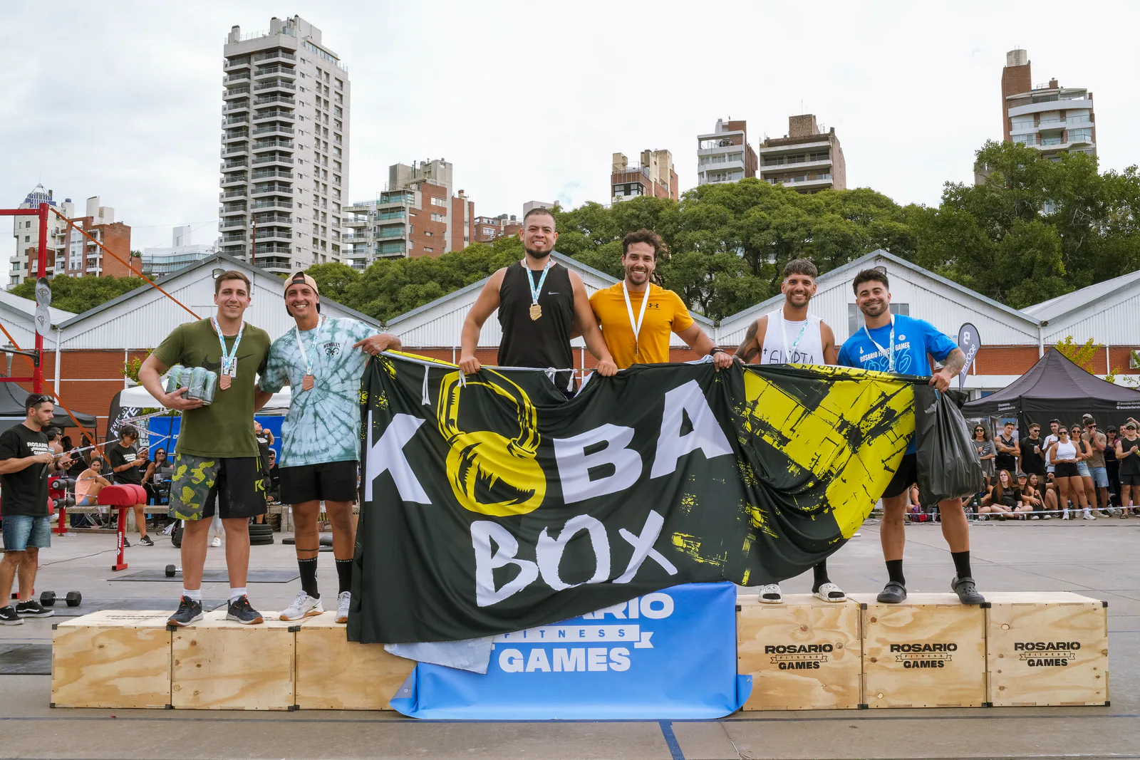 Equipo masculino celebrando en el podio con su bandera