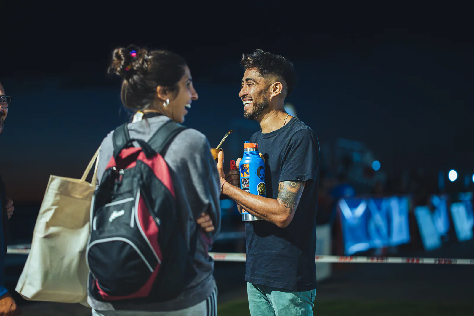 Integrantes de la comunidad conversando y sonriendo durante la noche